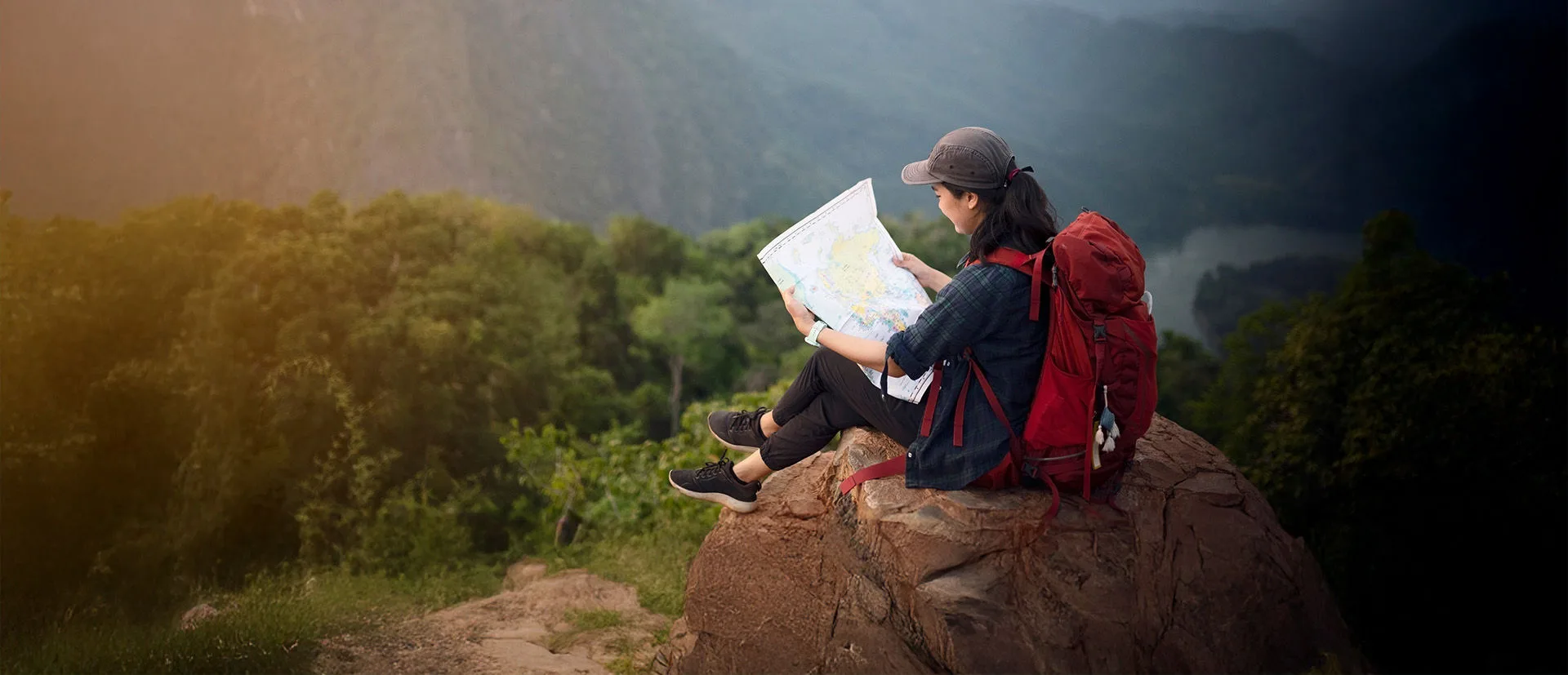 Frau mit Karte auf einem Felsen
